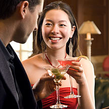 Woman holding drink in hand with man