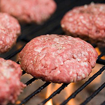 Raw burger patty on the grill